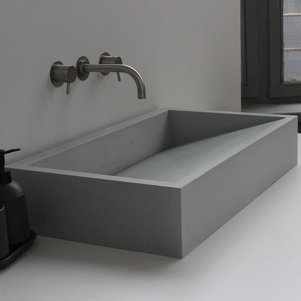 Vero concrete sink by Unrefined in light grey, wall-mounted in minimalist bathroom.